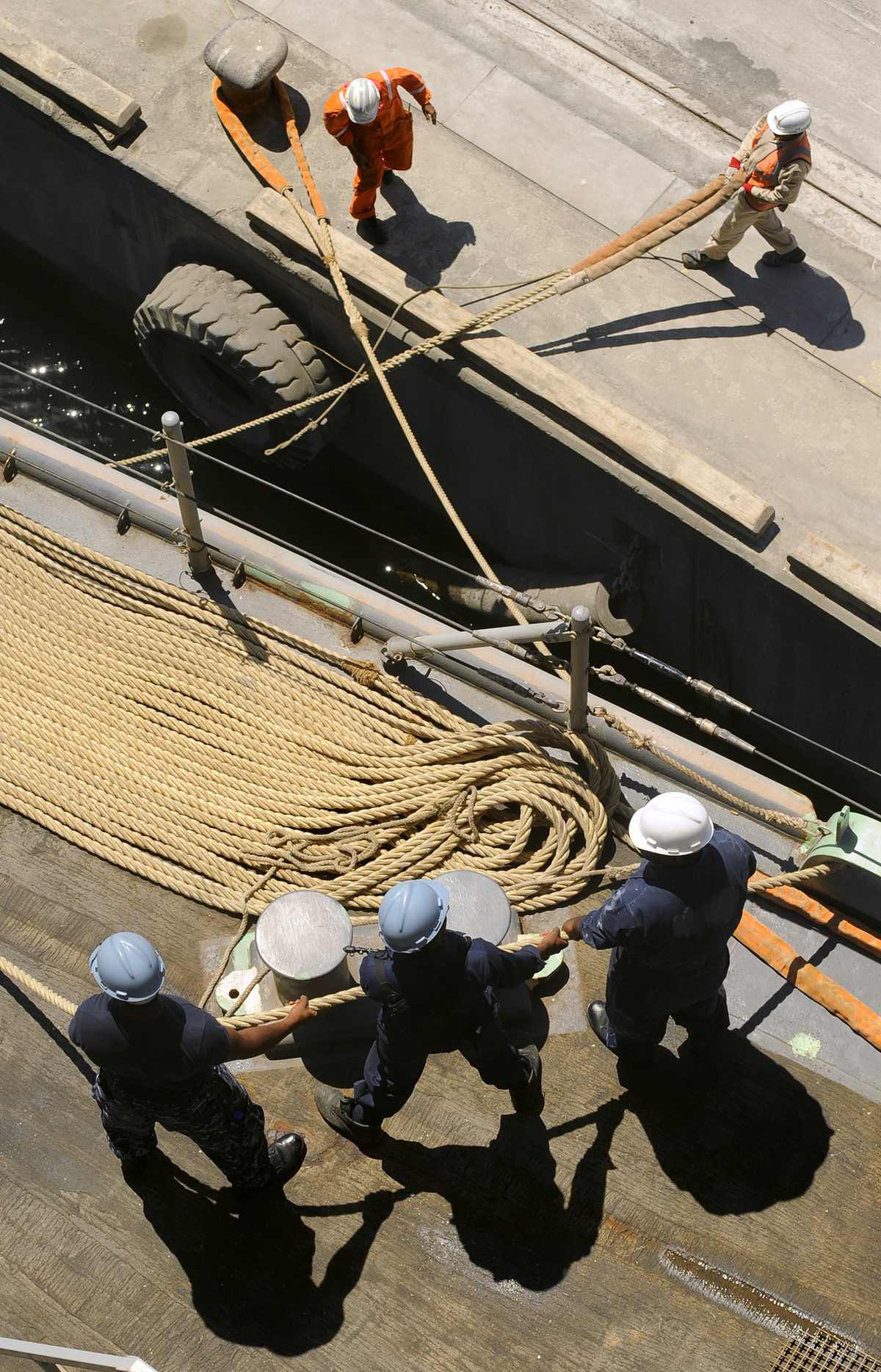 Port of Salalah — US Navy 090923-N-5345W-033 Deck department Sailors aboard the amphibious dock landing ship USS Fort McHenry (LSD 43) man a mooring line on the foc'sle as local port workers help moor the ship to the pier during a scheduled port.jpg