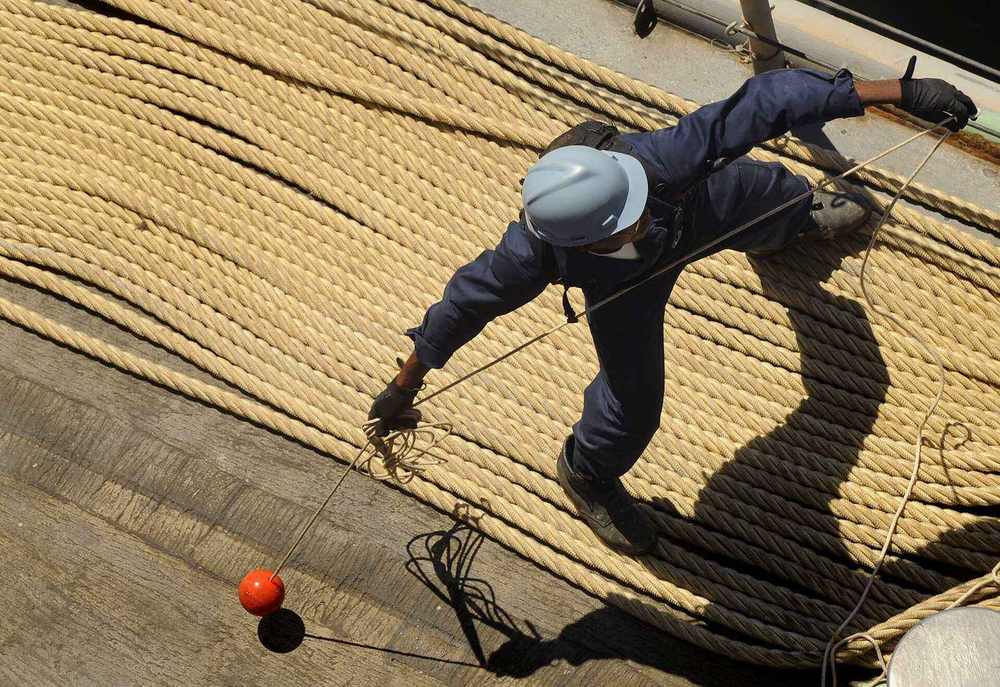 Port of Salalah — US Navy 090923-N-5345W-026 A deck department Sailor tosses a heaving line from the foc'sle of the amphibious dock landing ship USS Fort McHenry (LSD 43) as the ship moors pierside in Salalah, Oman, for a scheduled port visit.jpg